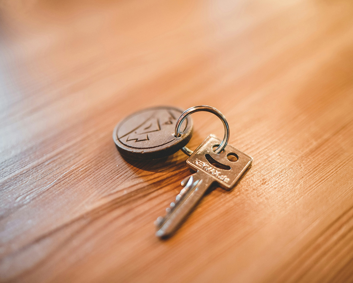 House key resting on a wood table, symbolizing home