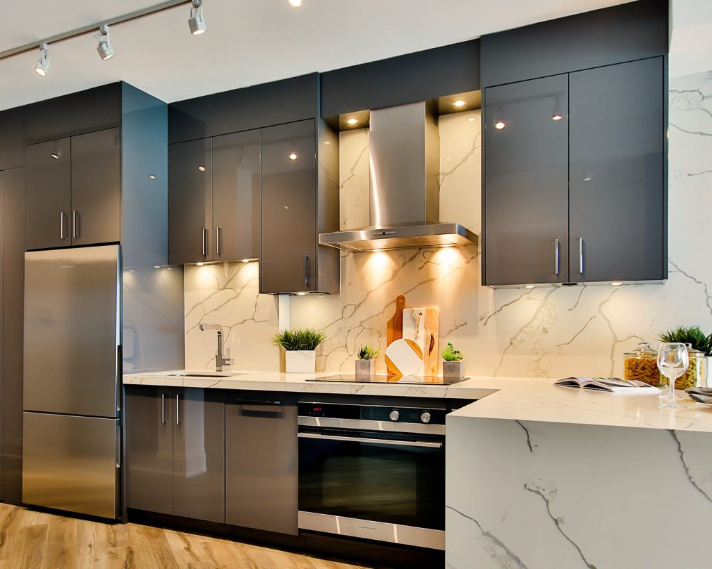 Navy blue kitchen with marble backsplash and stainless steel appliances